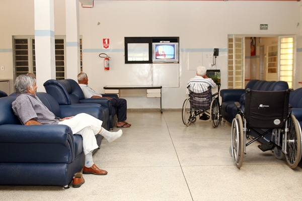 Idosos assistem televisão em abrigo: esquecidos por familiares e amigos, esperam uma visita
